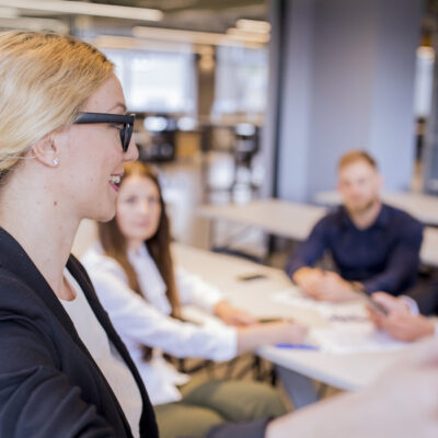 close-up-blonde-young-businesswoman-giving-presentation-meeting (1) (1)